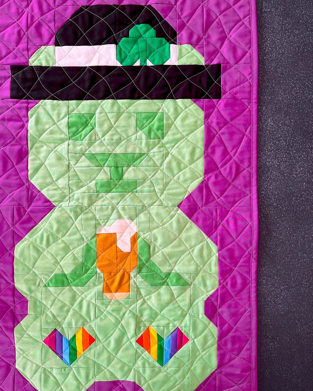 Beary O'Cheers a St Patricks Day themed bear quilt block pattern with a glass of bear, rainbow heart feet, and clover adorned hat