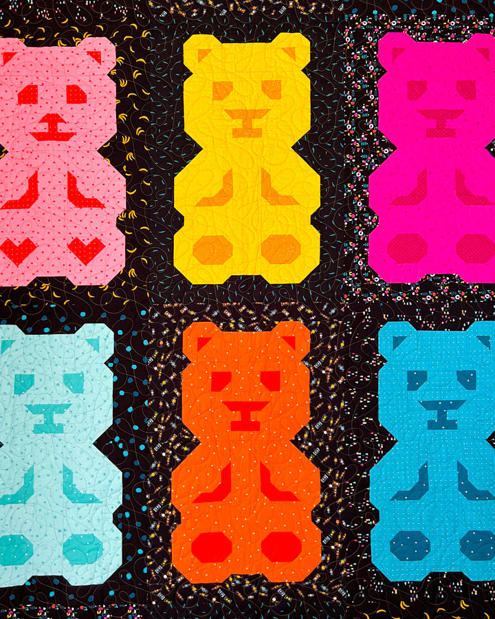 Colorful gummy bear-shaped quilt blocks on a black background
