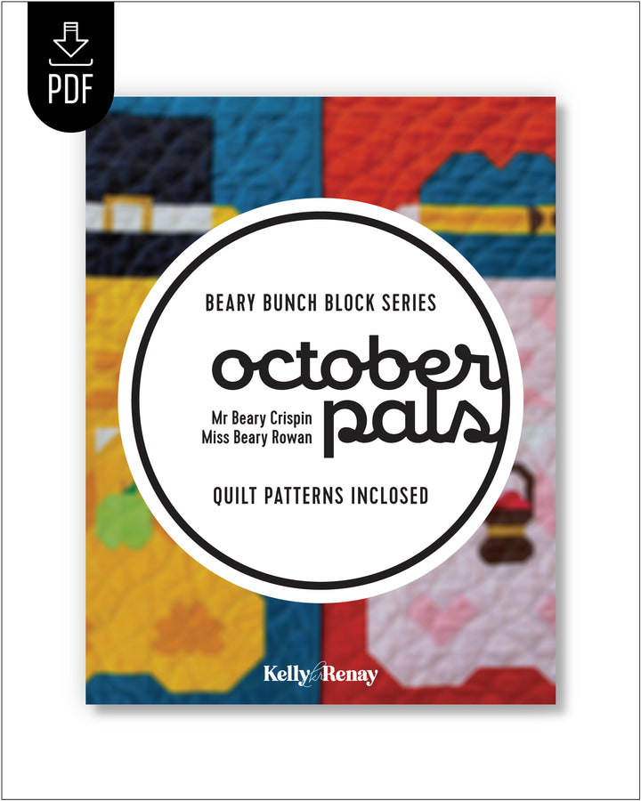 A booklet cover for a quilt pattern titled "October Pals" from the Beary Bunch Block Series, with a colorful quilt background and a large white circle containing the title. A black PDF download icon appears in the top-left corner.